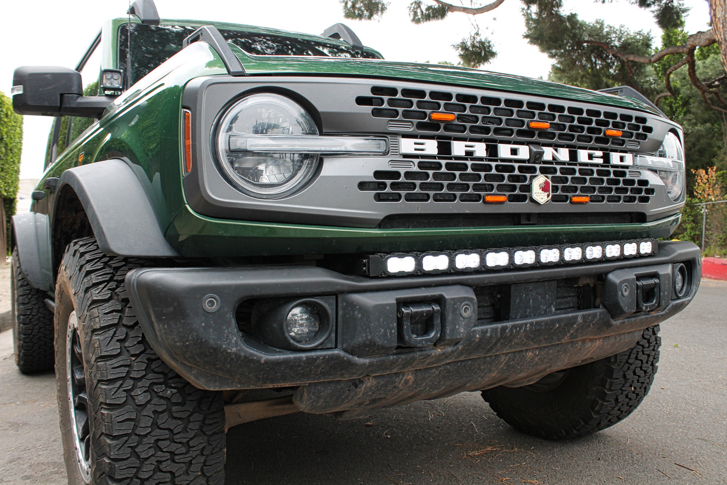 Green Ford Bronco truck with visible branding and front LED light bar