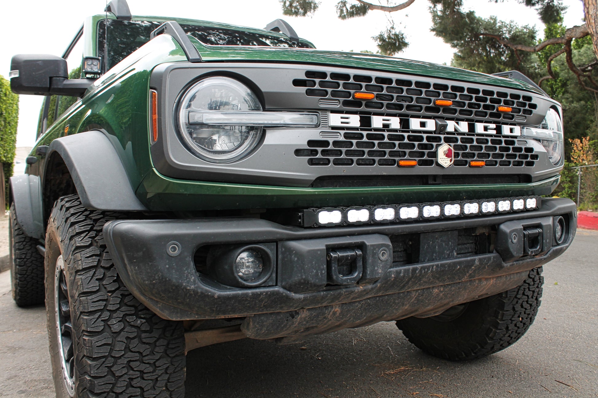 Green Ford Bronco truck with visible branding and front LED light bar