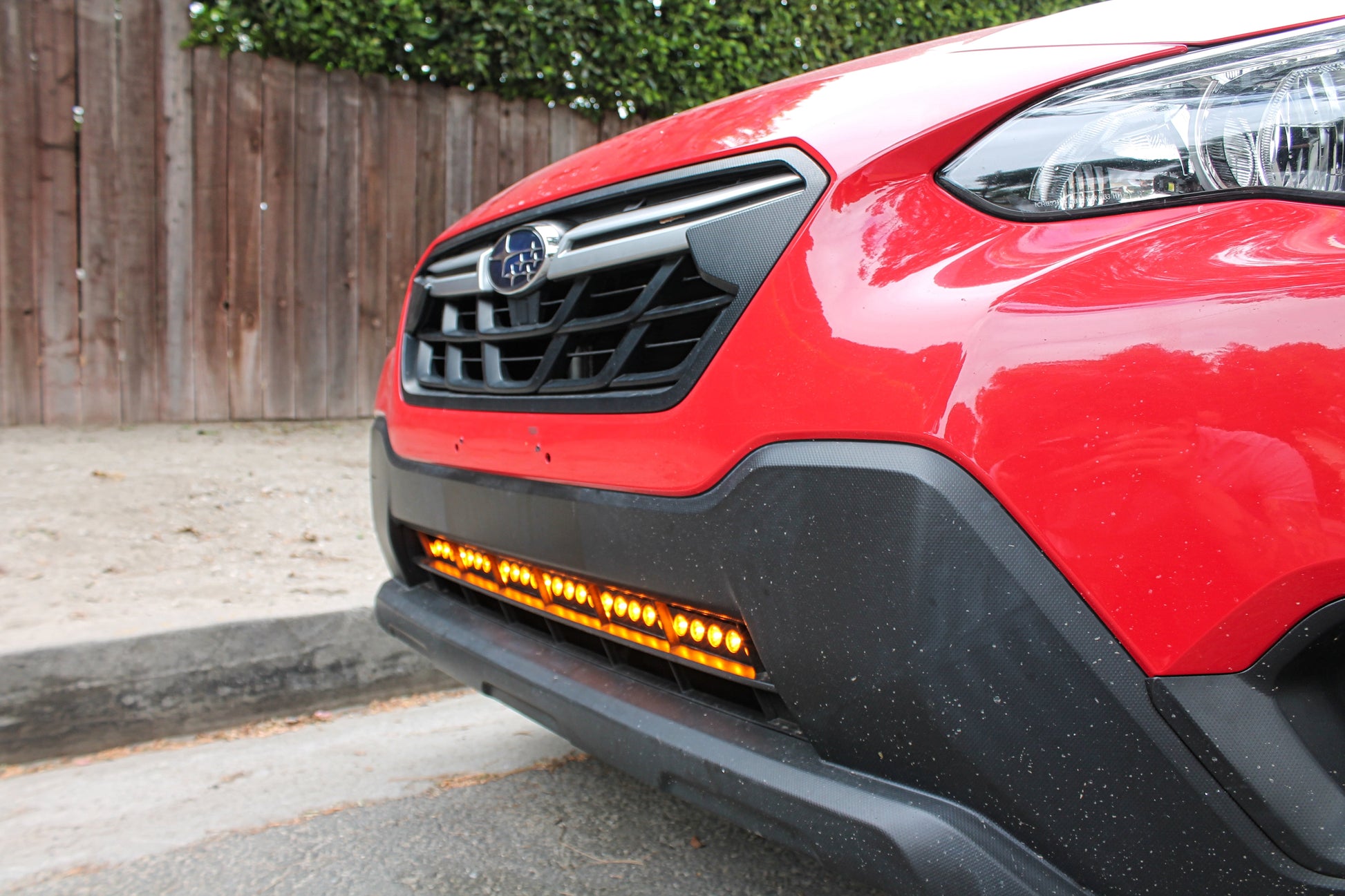 Red car with a visible LED Light Bars, parked on a street.
