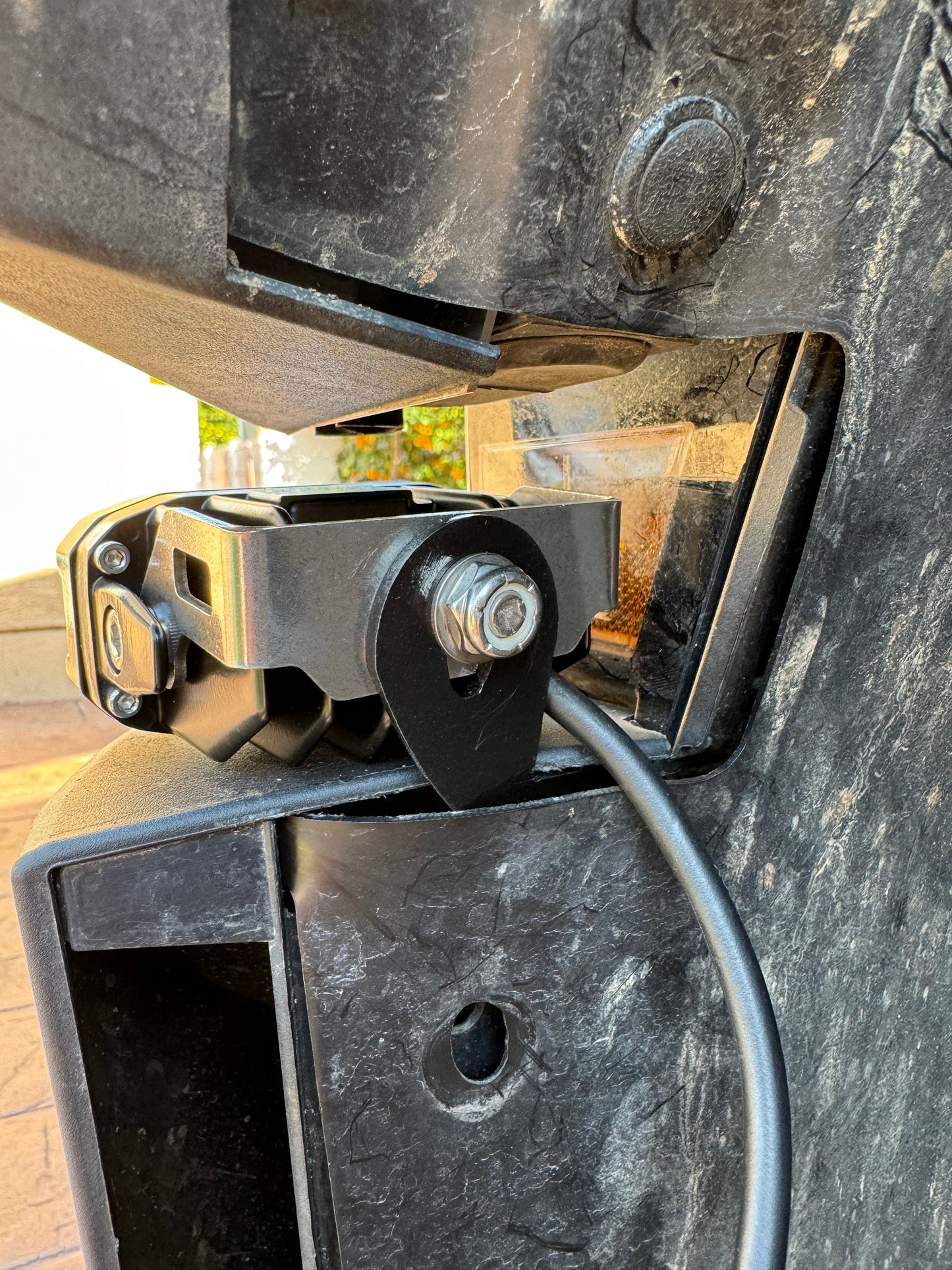 Close-up of a metal bracket with a cable attached