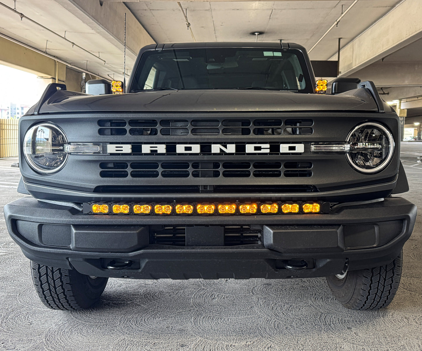 Front view of a black Ford Bronco truck in an indoor setting with amber LED Light Bar