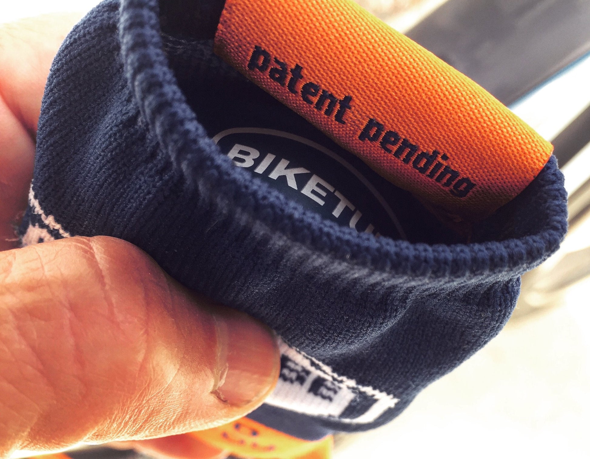 Close-up of a blue and orange handlebar grip with 'BIKETU' branding.