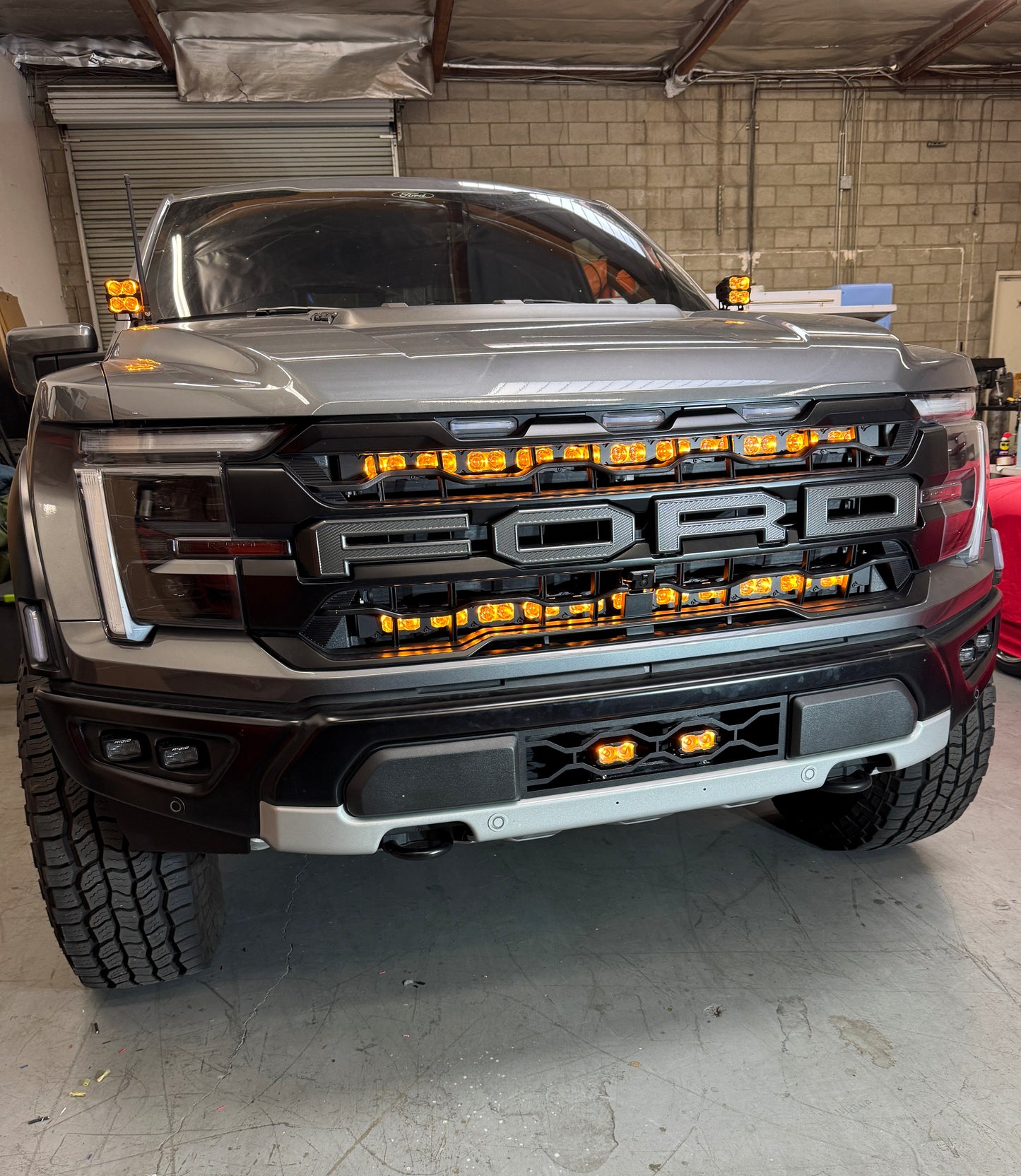 Ford truck with illuminated grille with a Ford Raptor Gen 3 Refresh Guard Plate in a garage