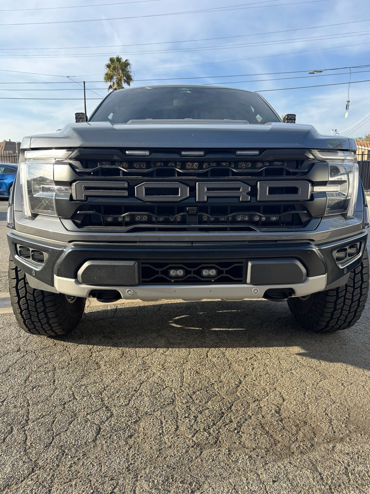 Front view of a Ford truck on a paved surface with a clear sky.