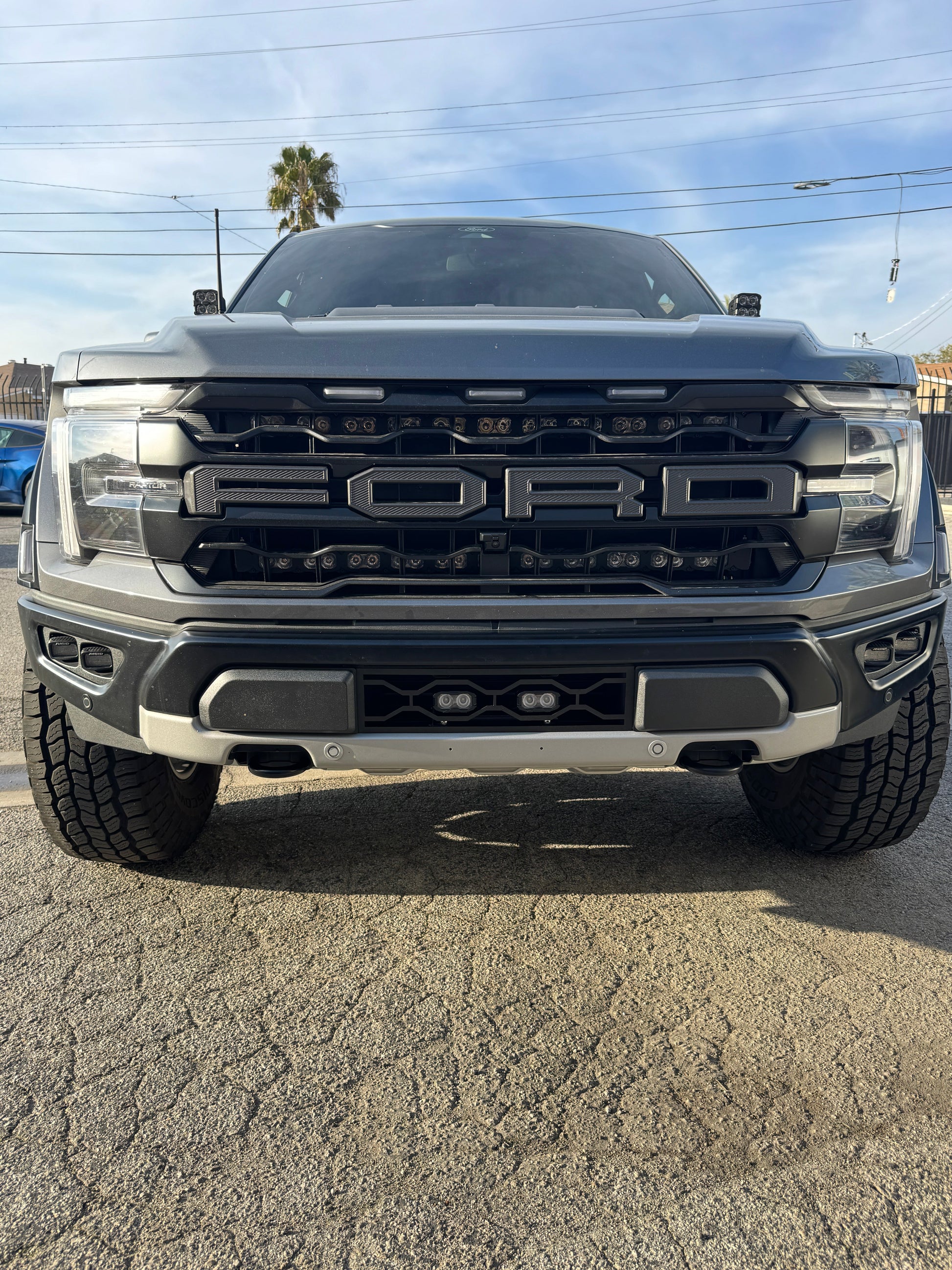 Front view of a Ford truck on a paved surface with a clear sky.