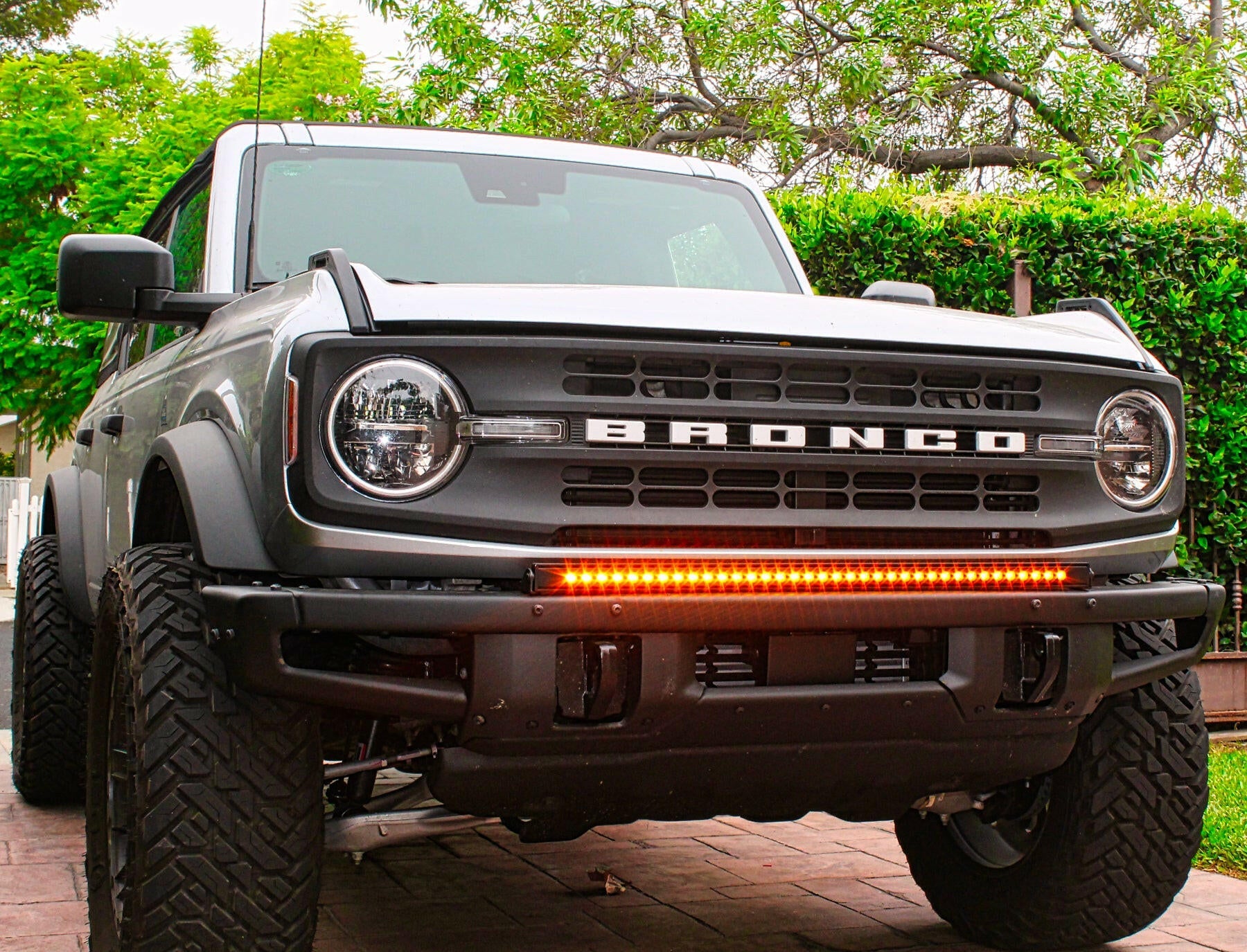 Ford Bronco truck with visible branding and LED Light Bars on a paved surface with greenery in the background