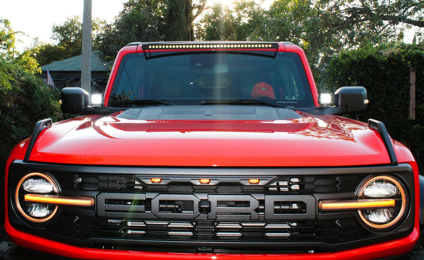 Red Ford truck with illuminated headlights and LED Light Bar on top.