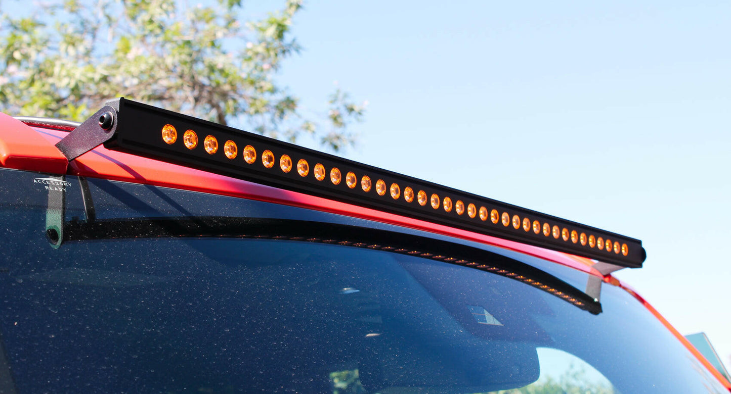 Car roof with an LED amber light bar attached, outdoors.