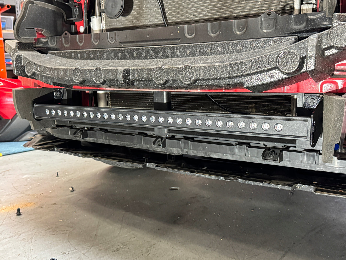Close-up of a vehicle's rear bumper with LED lights in an indoor setting
