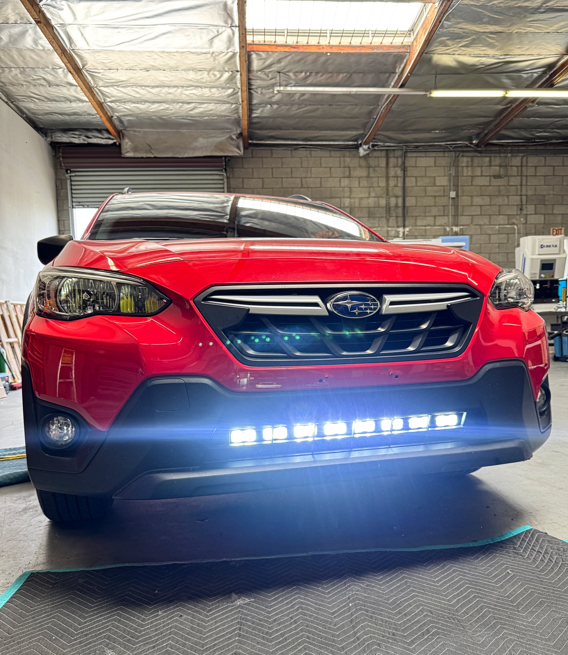 Red SUV with LED lights on in a garage setting