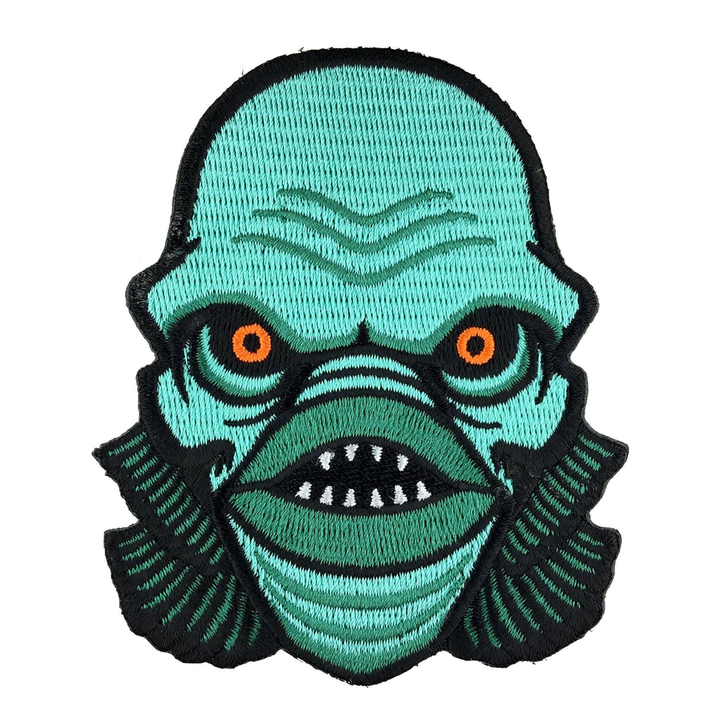 Embroidered patch of a green creature with orange eyes on a white background