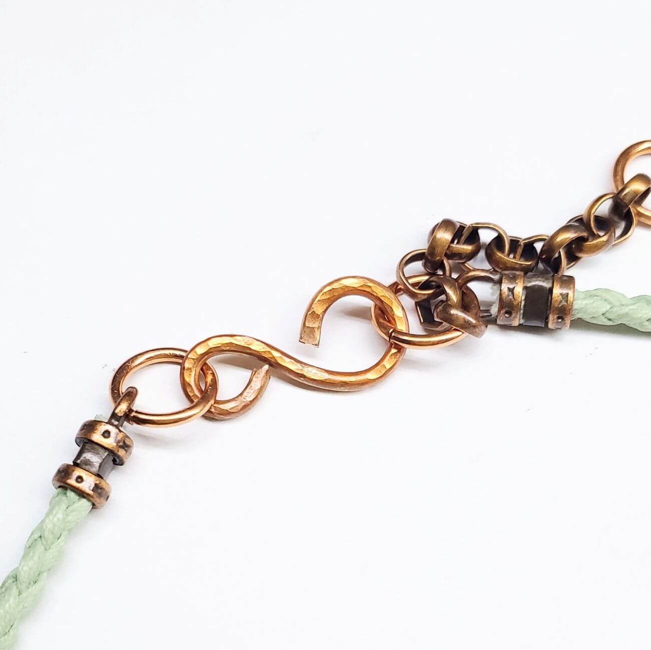 Autism Necklace with gold chain and green leather strap on a white background