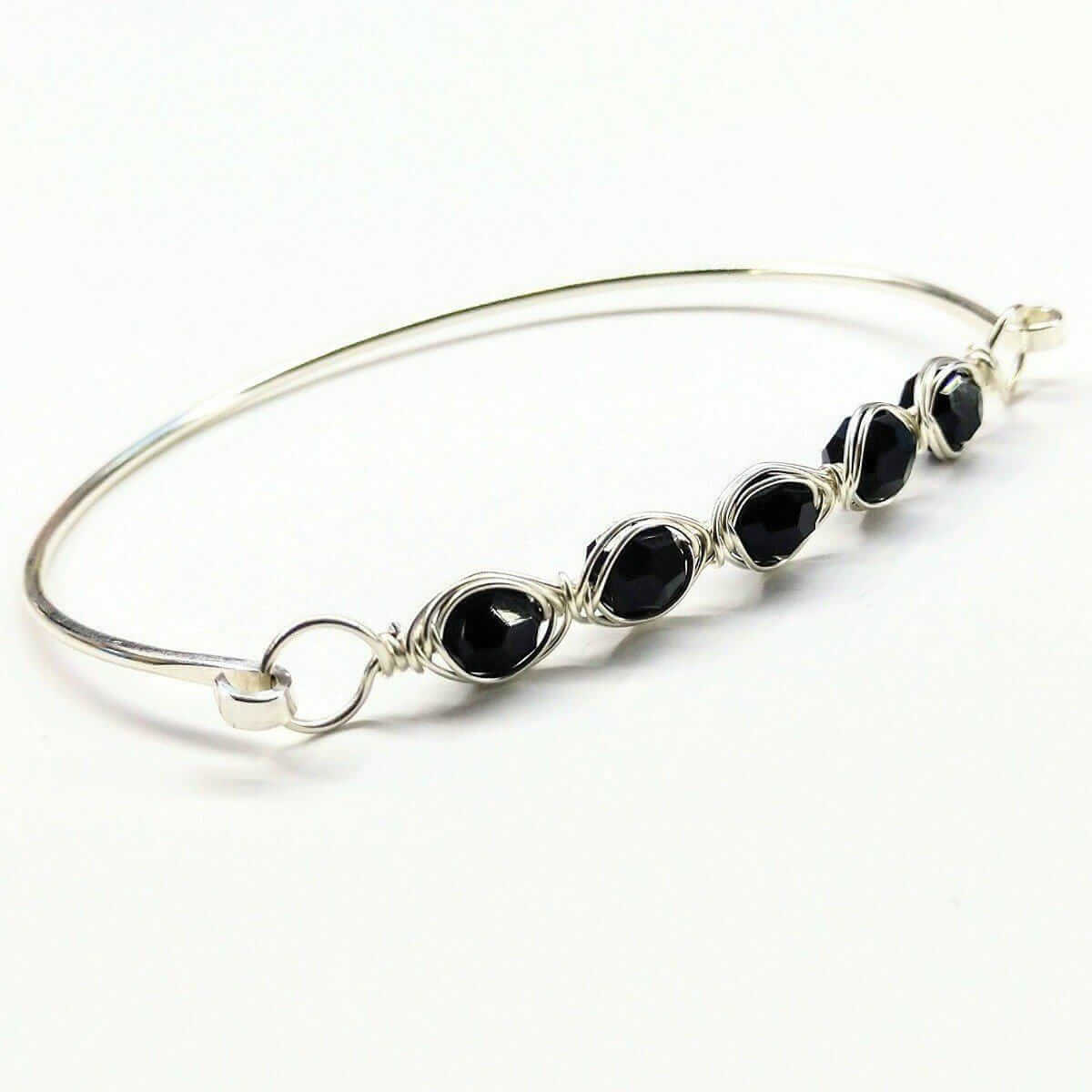 Silver bracelet with black stones on a white background
