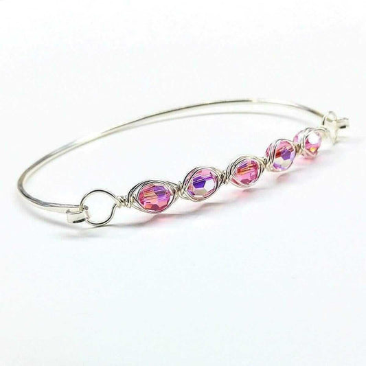Silver bangle with pink and purple crystal beads on a white background