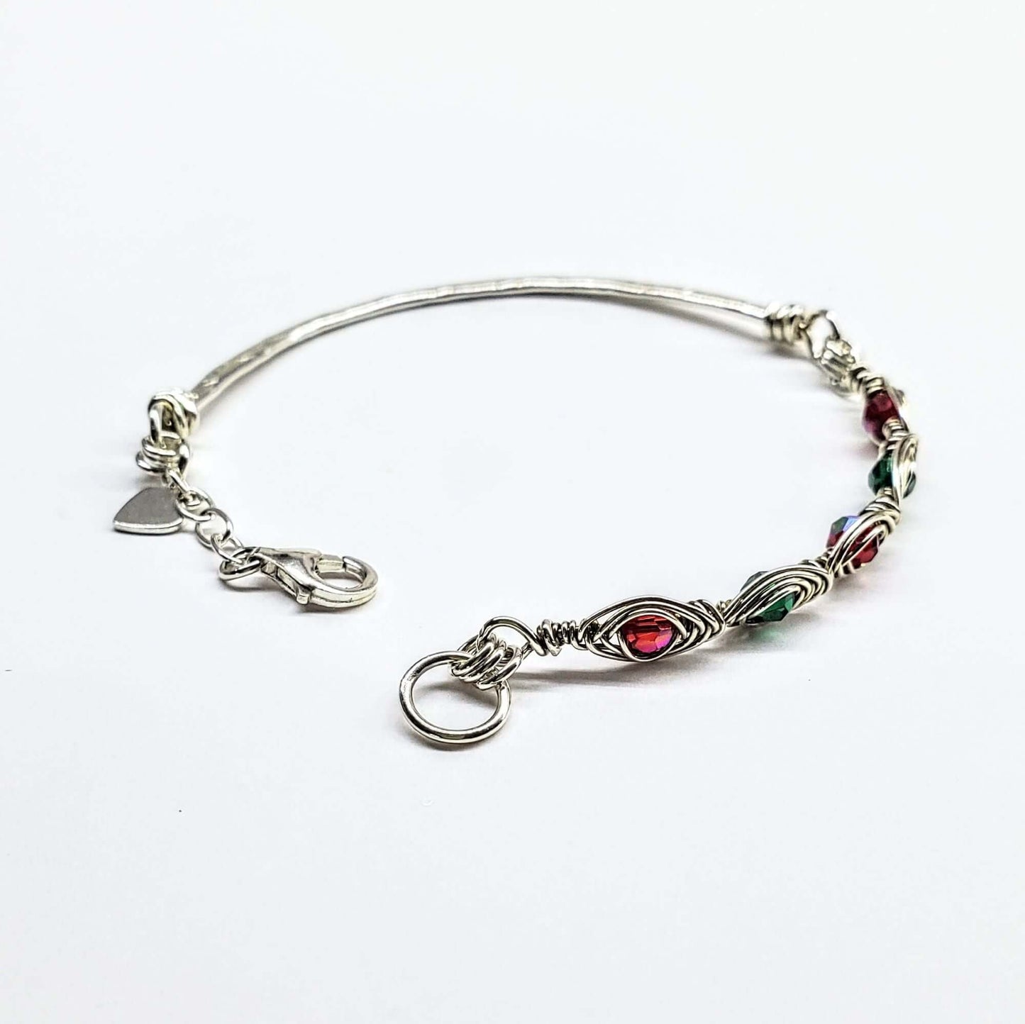 Silver bracelet with colorful beads and charms on a white background
