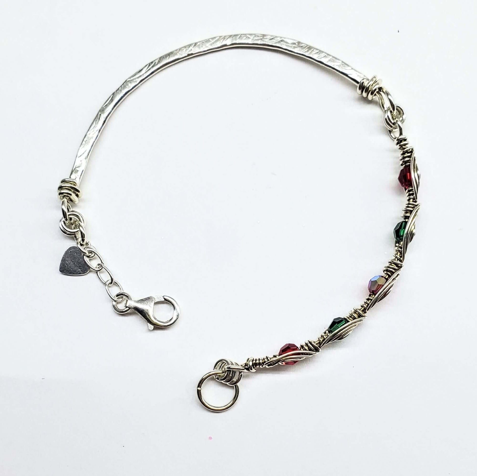 Silver bracelet with colorful beads and charms on a white background