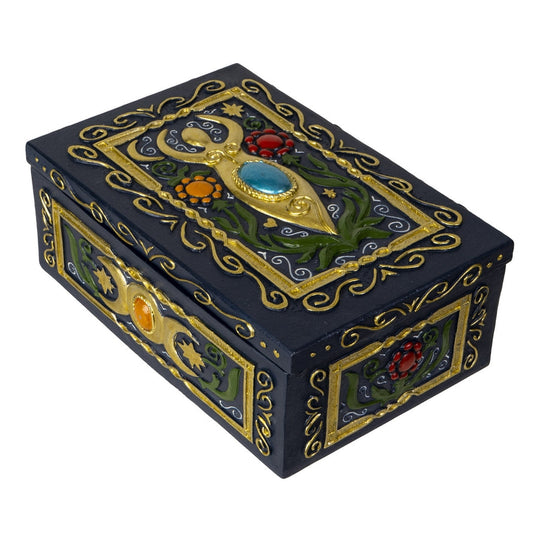 Decorative black box with gold and gemstone accents on a white background