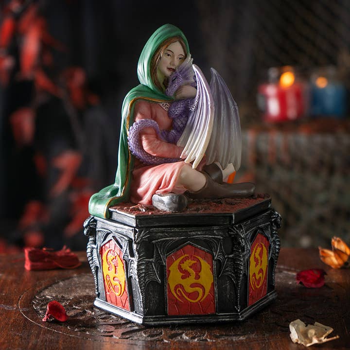 Statue of a woman with a baby dragon on a dark background