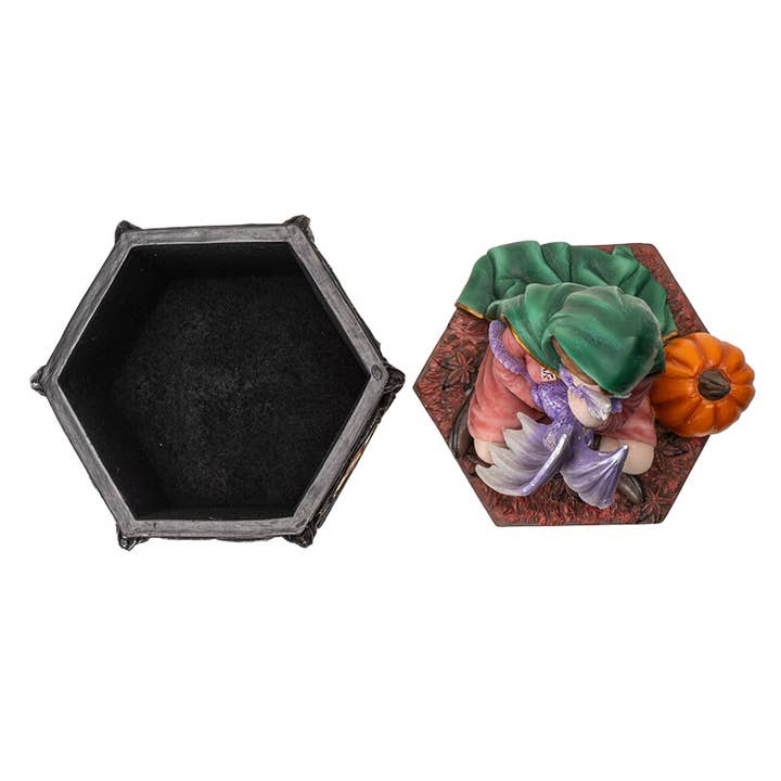 Hexagonal black box with a decorative lid featuring a woman and pumpkin on a white background