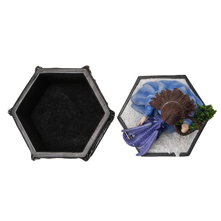 Hexagonal black container with a figurine of a person in a blue dress and hat on a white background