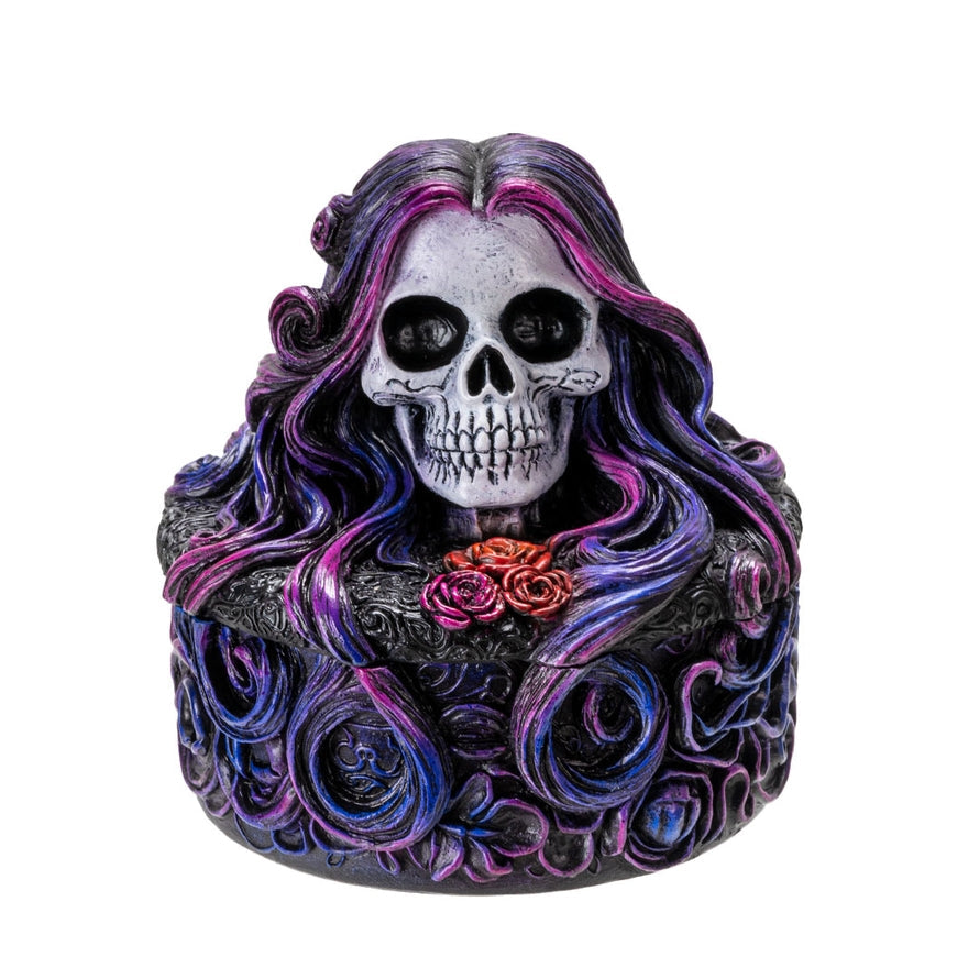 Decorative skull figurine with purple hair and a rose on a white background