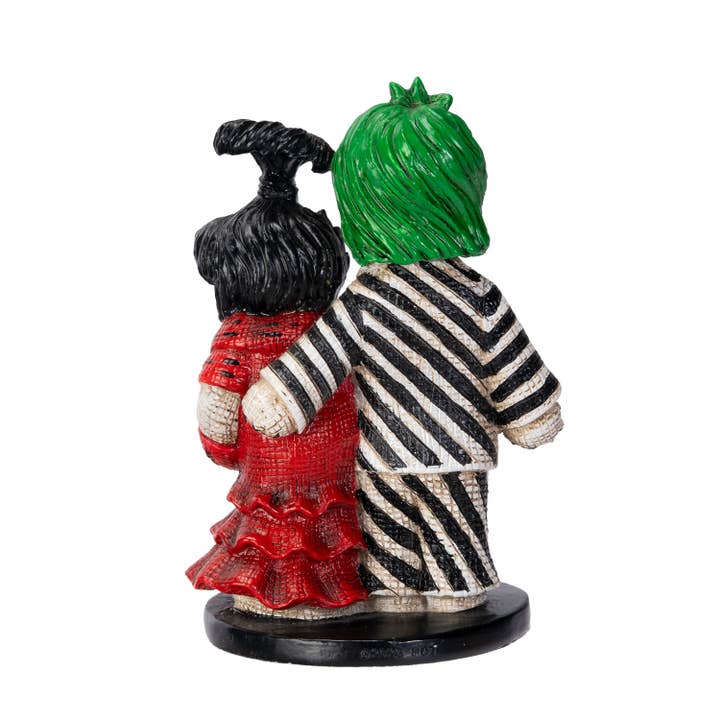 Two colorful figurines with striped outfits and a green head on a white background