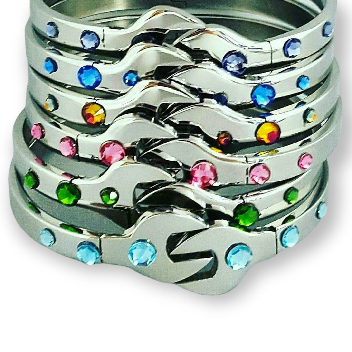 Stack of silver bracelets with multicolored gemstones on a light gray background