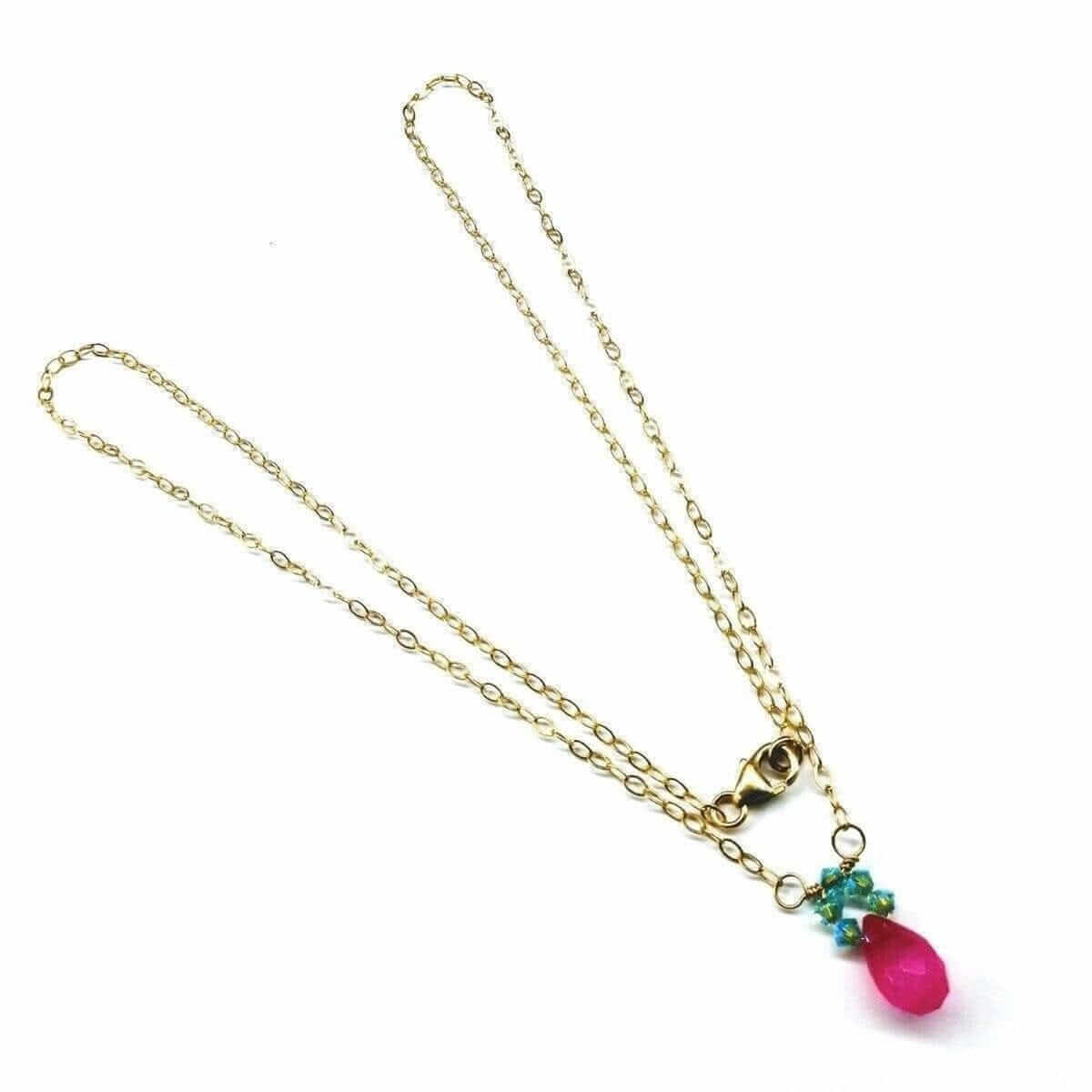 Gold necklace with a pink teardrop pendant on a white background