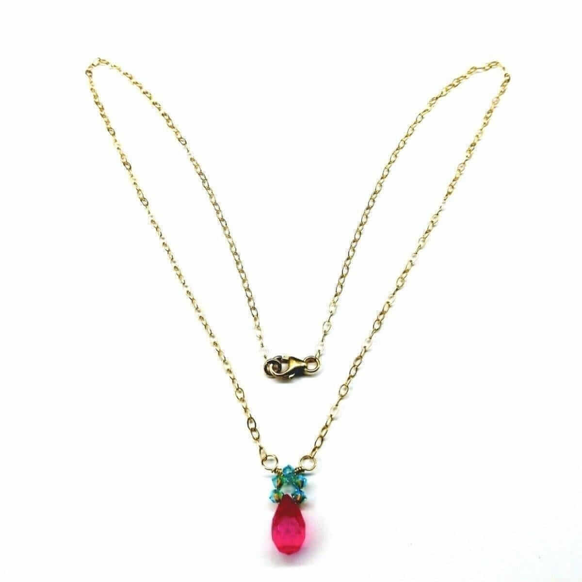 Gold necklace with a pink teardrop pendant on a white background