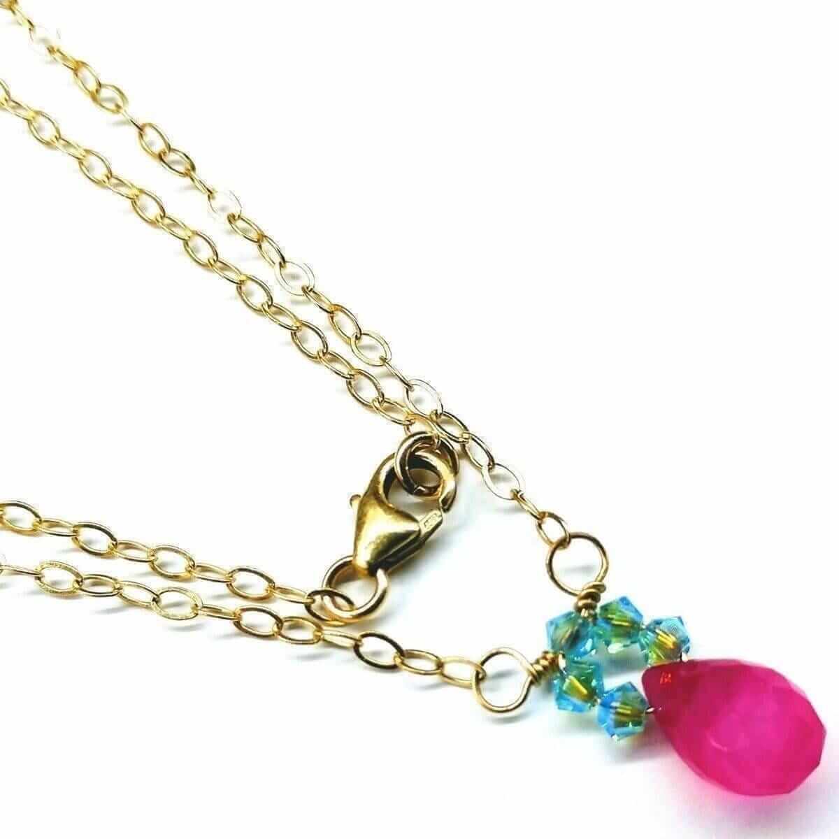 Gold necklace with a pink teardrop pendant and blue beads on a white background