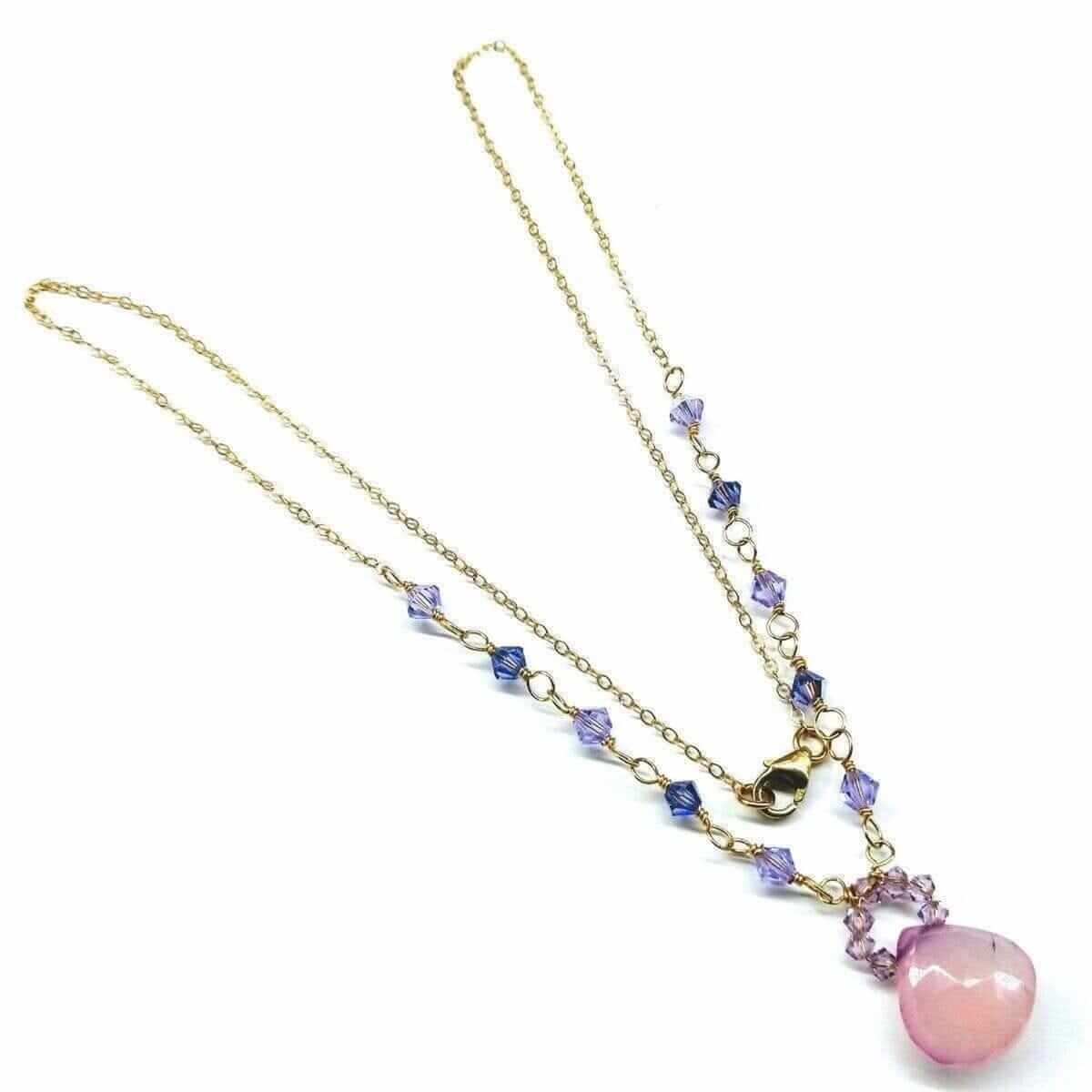 Necklace with pink pendant and gold chain on a white background