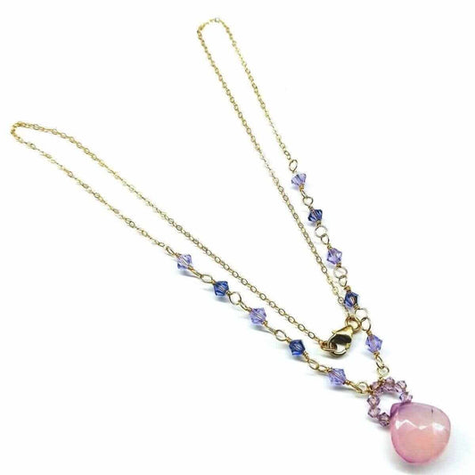 Necklace with pink pendant and gold chain on a white background