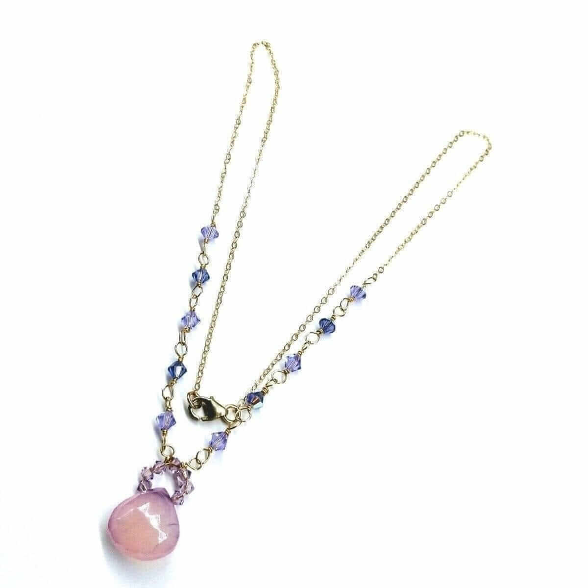 Necklace with pink pendant and blue beads on a white background