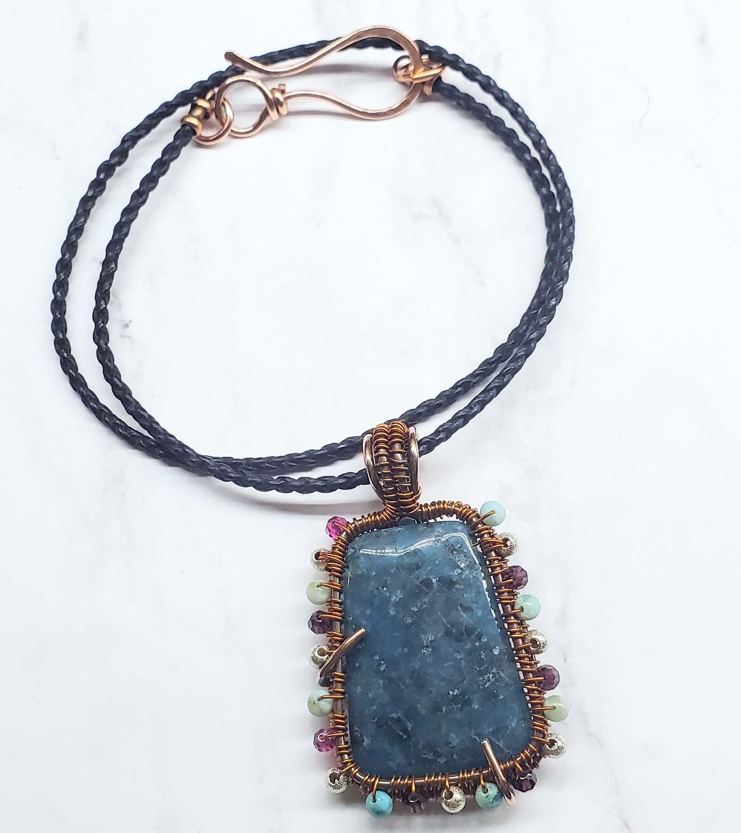 Necklace with a blue stone pendant on a white background