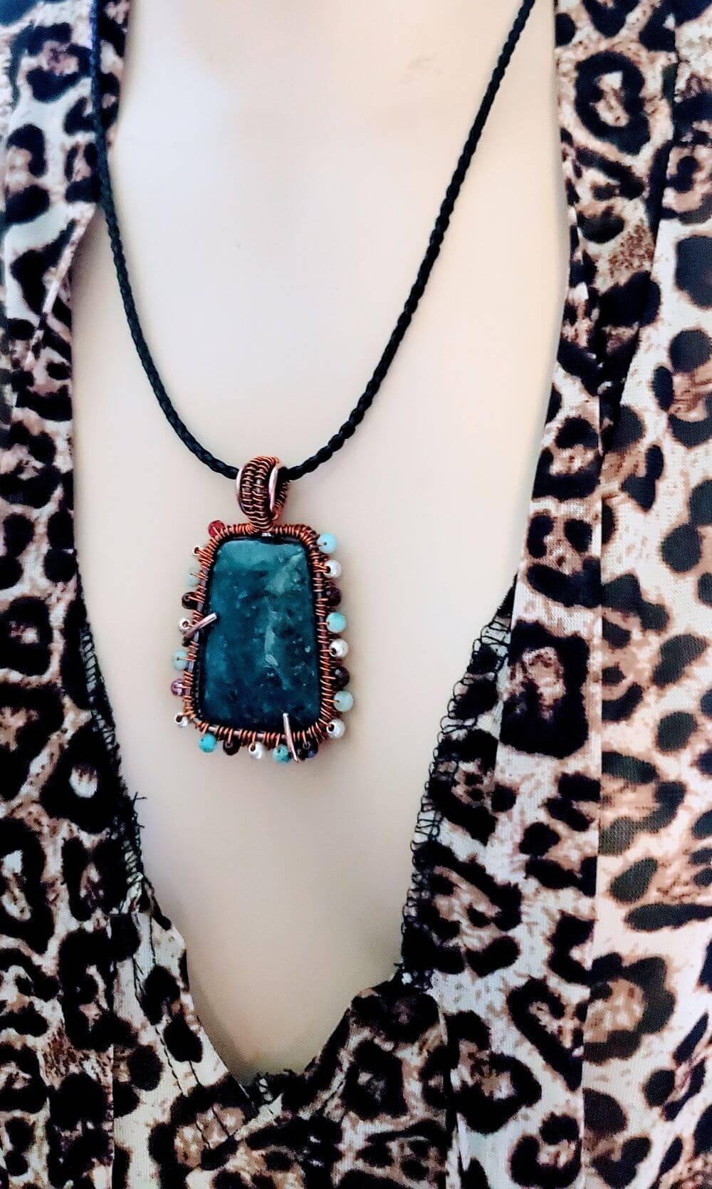 Blue pendant necklace on a mannequin with leopard print clothing