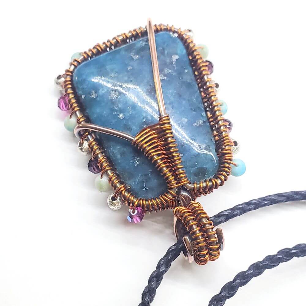 Jewelry with a large blue stone and wire wrapping on a white background