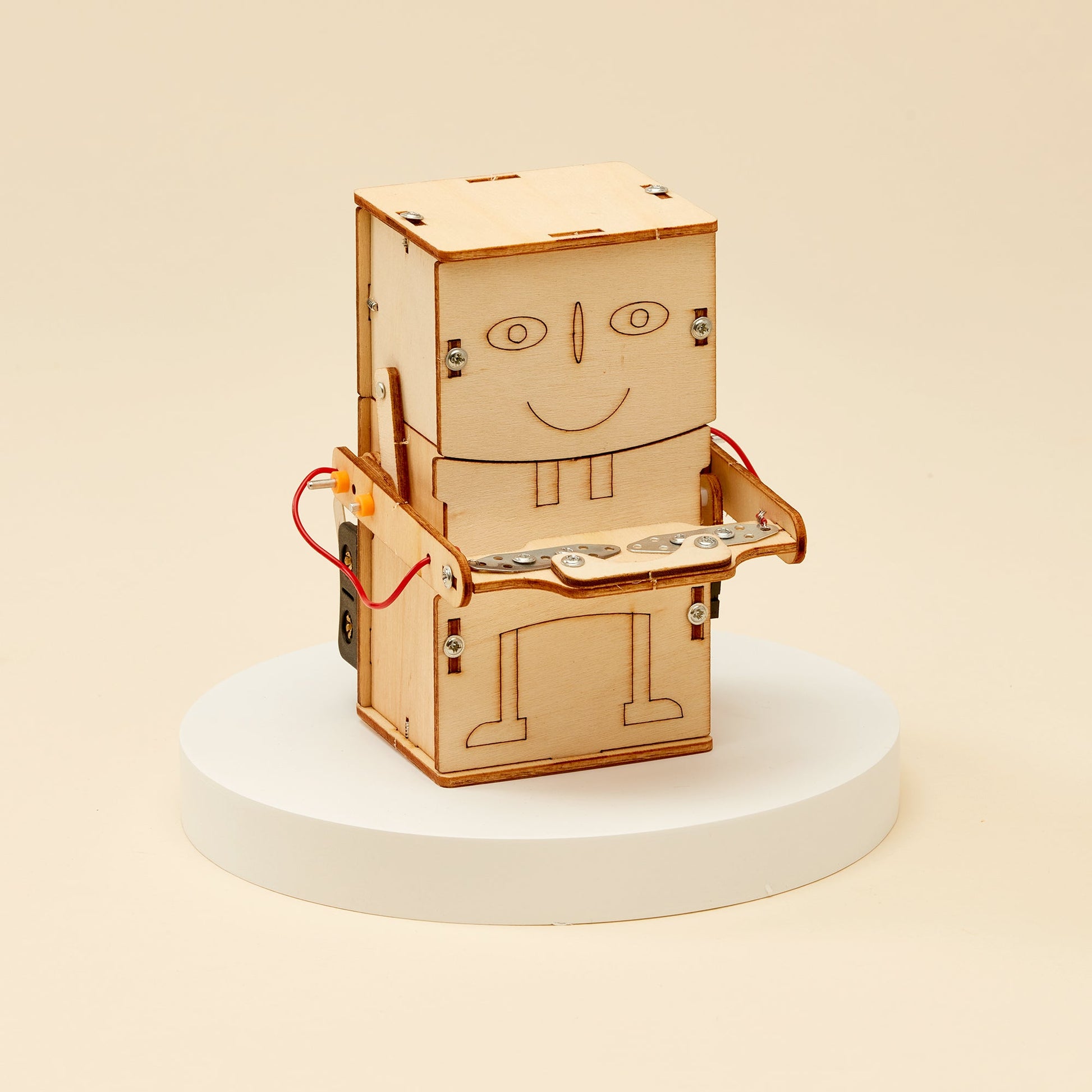 Wooden robot model on a white pedestal with a beige background