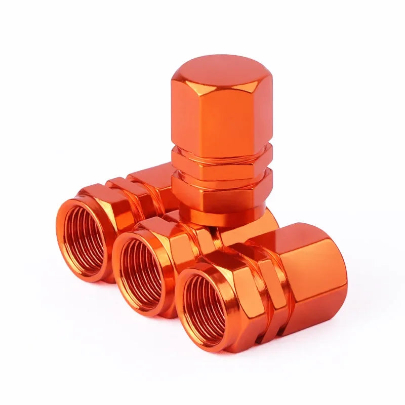 Orange metal valve stem caps on a white background