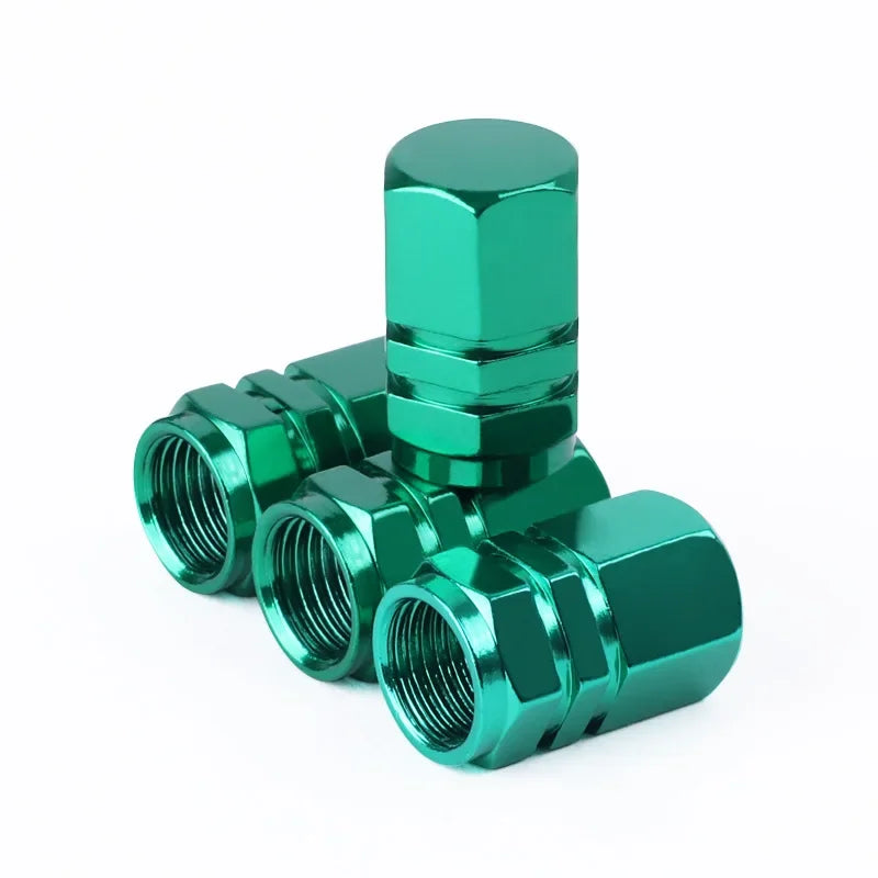 Green metal valve stem caps on a white background