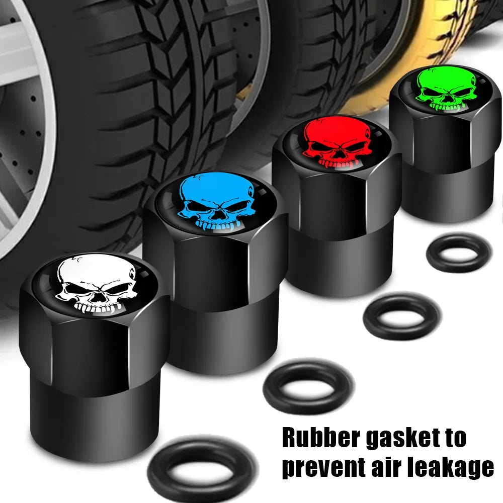 Set of black skull-shaped valve stem caps with colorful centers next to a tire, featuring rubber gaskets.
