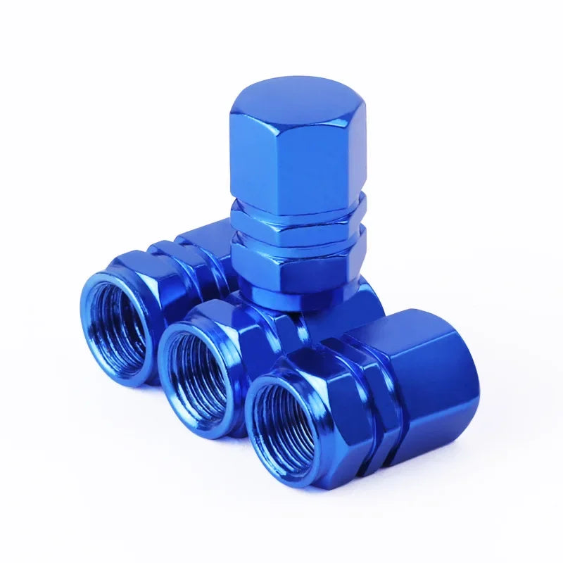 Blue metal valve stem caps with three threaded ports on a white background