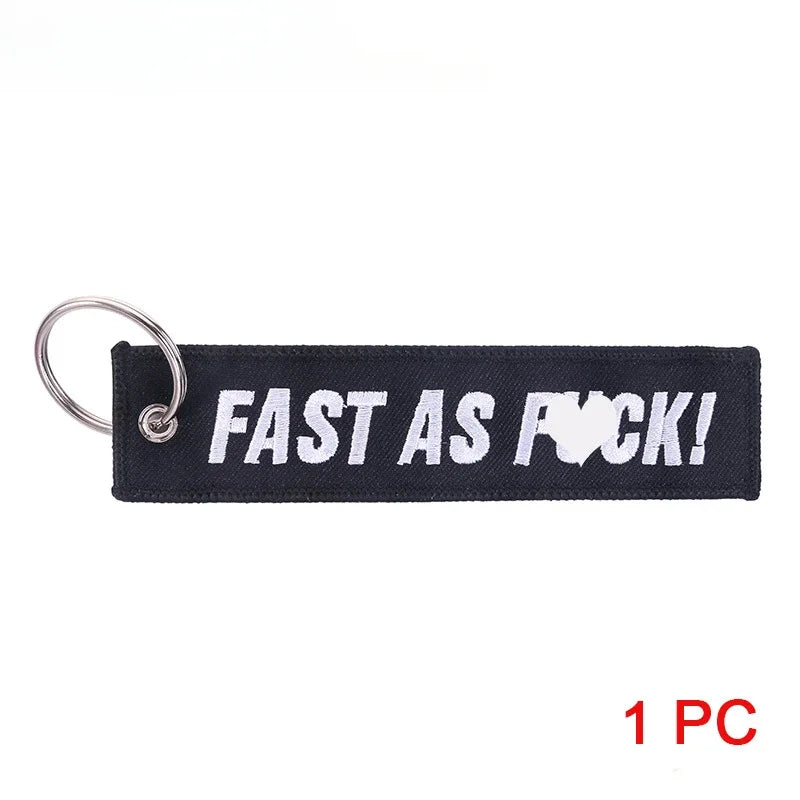 Black keychain with white text 'FAST AS FUCK!' on a white background