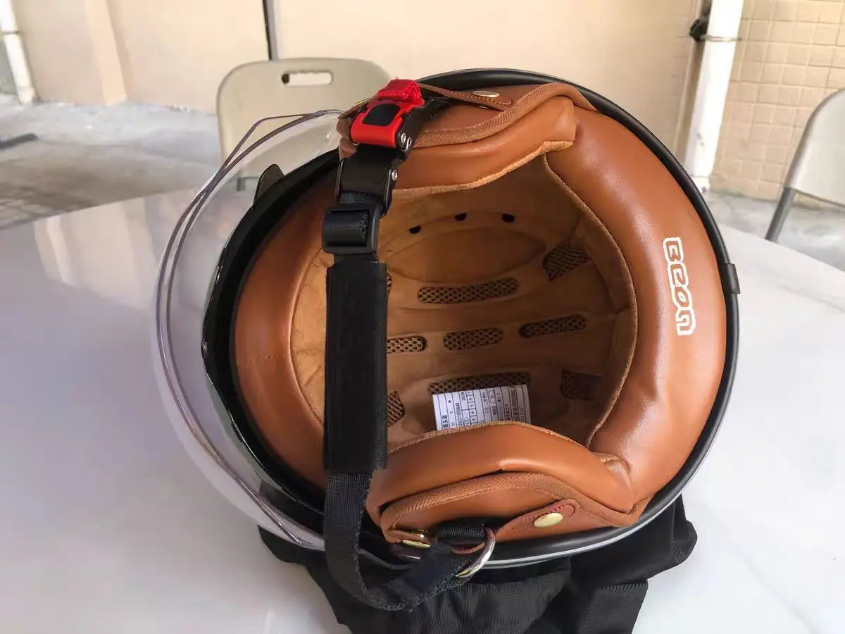 Brown leather helmet with black interior on a white surface