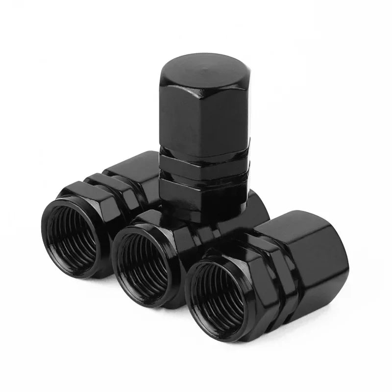 Black metal valve stem covers on a white background