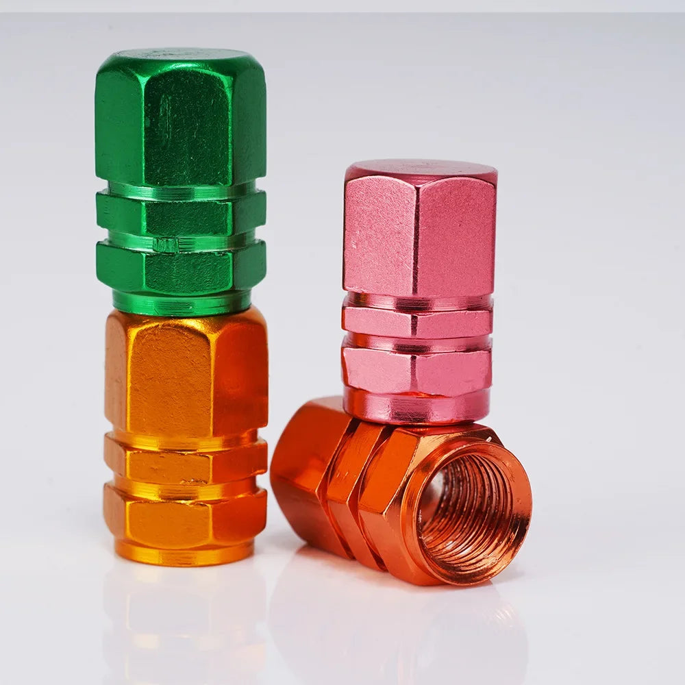 Three colorful metal valve caps on a white background