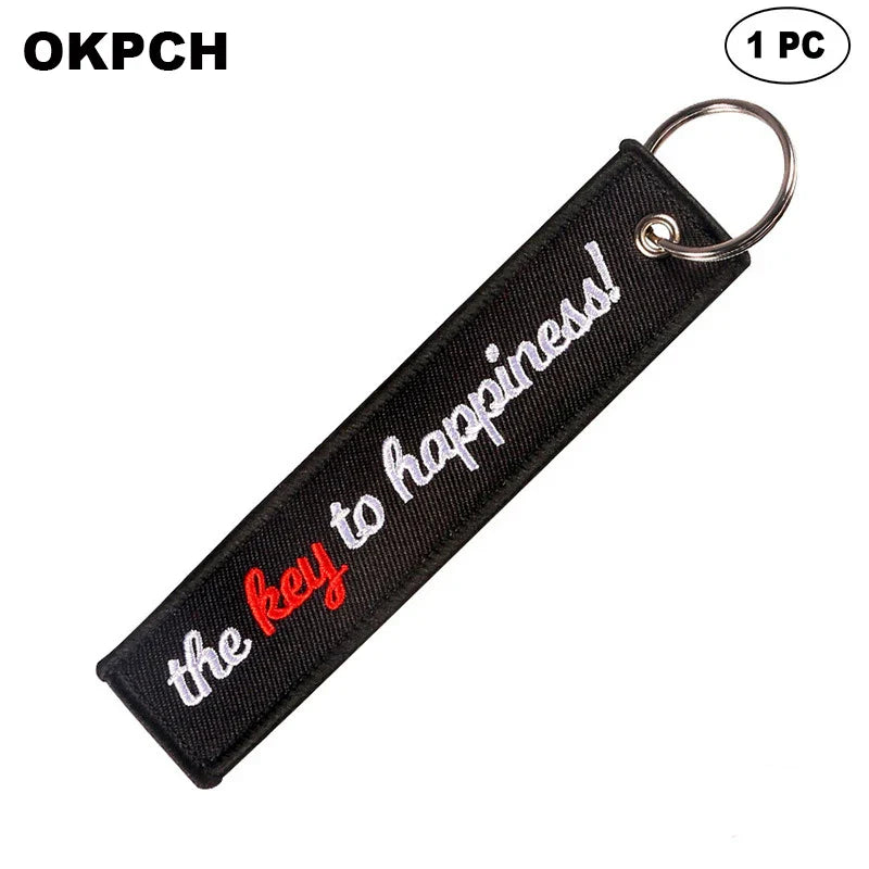 Black keychain with 'the key to happiness!' text on a white background
