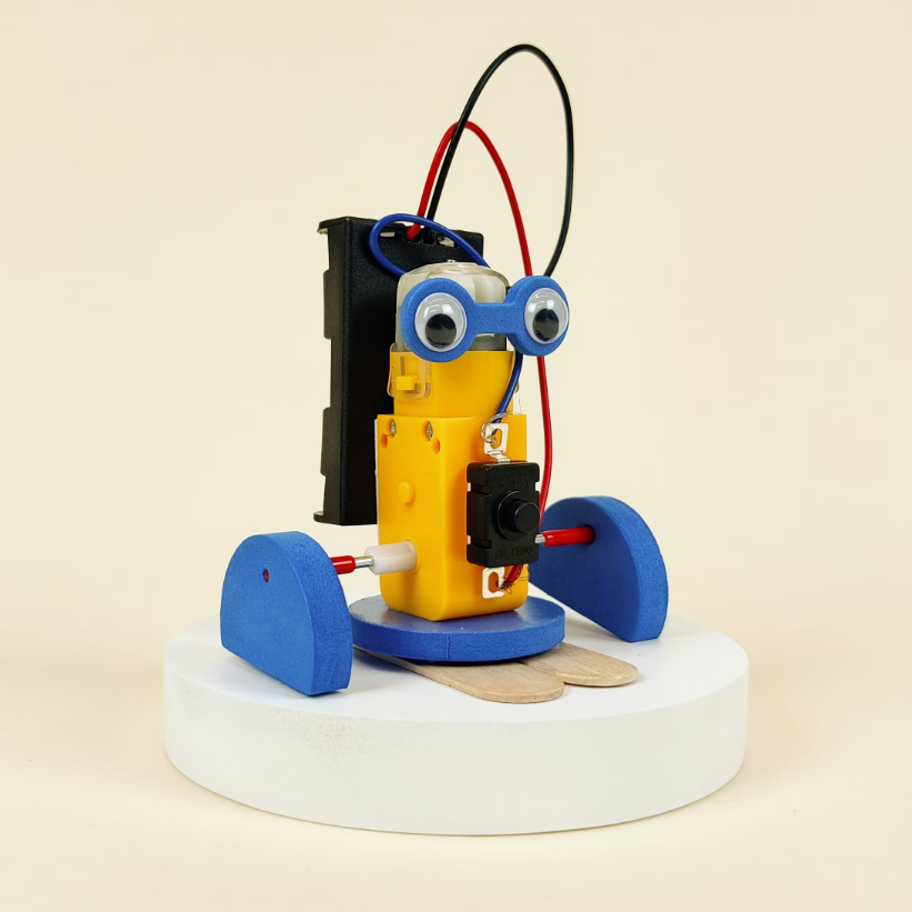 Toy robot with googly eyes and blue wheels on a beige background
