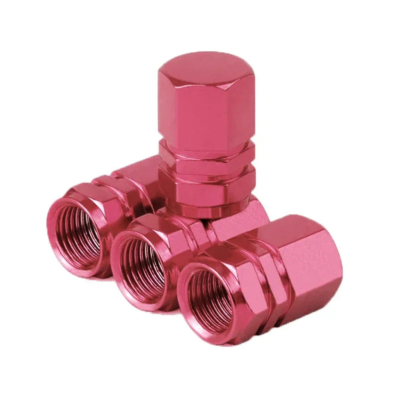 Pink metal valve stem caps on a white background