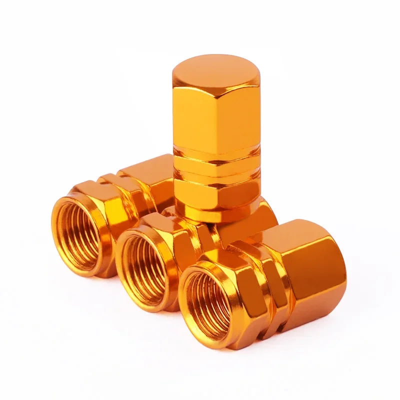 Gold metal valve stem caps on a white background