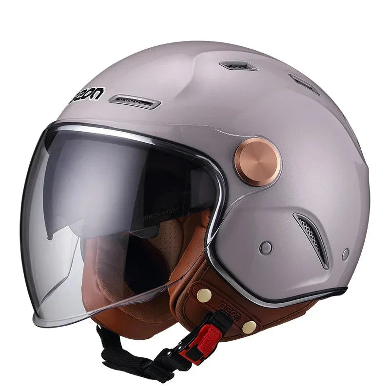 Gray motorcycle helmet with brown leather chin strap on a white background